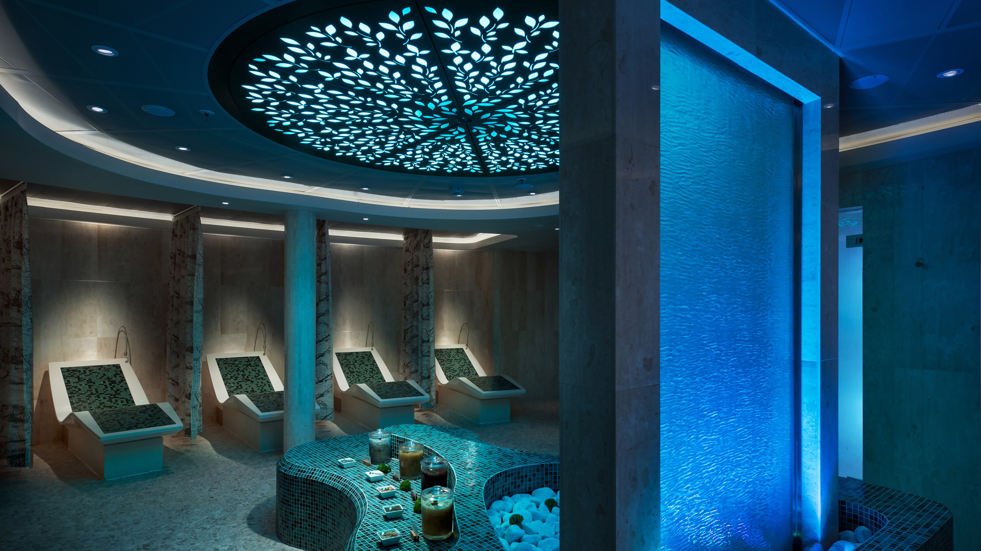 Unwind and let the tension melt away at The Rainforest at Senses Spa. A spa with a fountain, seats and candles