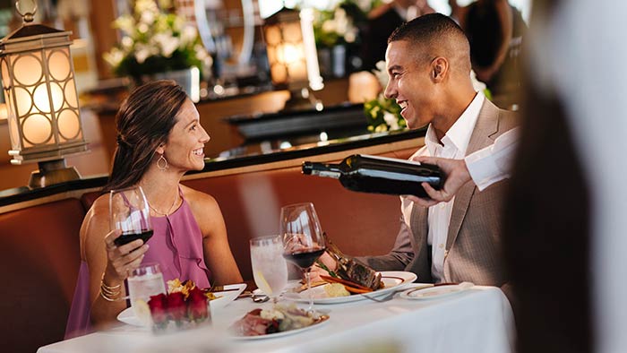 Un couple boit du vin à une table
