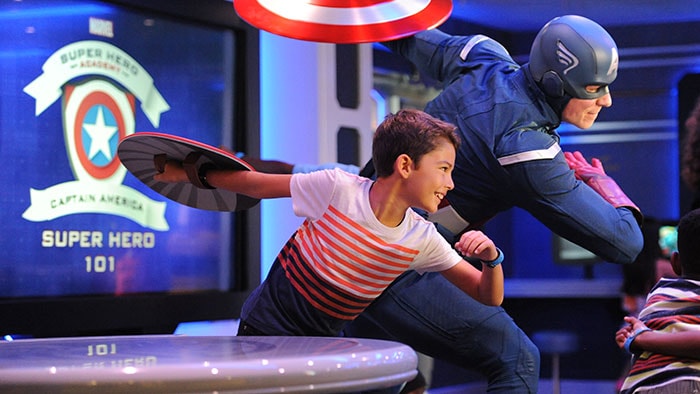 Un garçon pose à côté de Captain America
