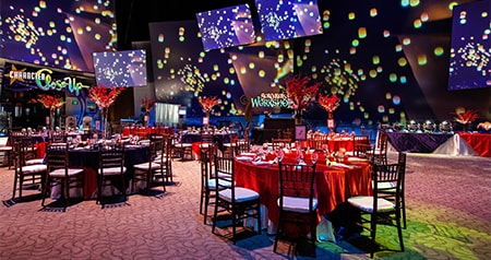 Set tables at a ballroom with Disney animation projected on panels