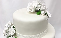 A 2 tier wedding cake topped with flowers