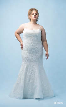 A bride wearing a Tiana inspired sheath gown featuring beading, sequins and a spaghetti strap neckline