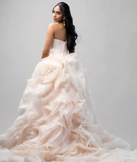 The back of a bride wearing a Belle inspired ball gown featuring a ruffled train