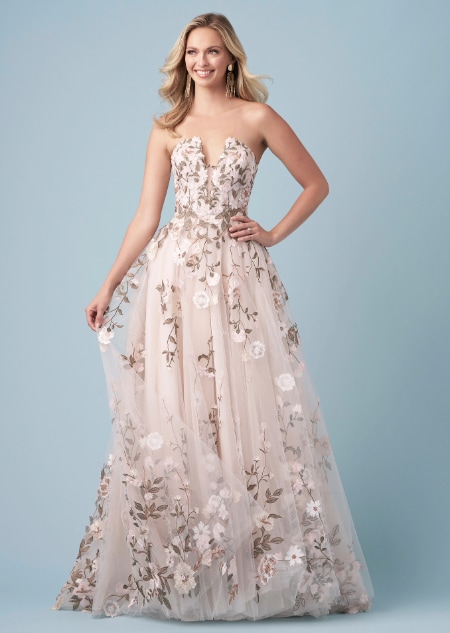 A bride wearing a Pocahontas inspired A line wedding gown featuring a plunging illusion neckline and embroidery of leaves and blossoms