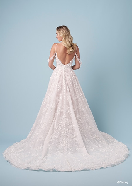 The back of a bride wearing a Snow White inspired A line wedding gown featuring embroidery, spaghetti straps, an exposed back and lace off the shoulder sleeves