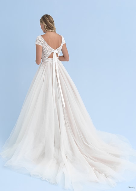 The top of a wedding dress ties around a bride’s back in a bow, while the bottom has a full skirt