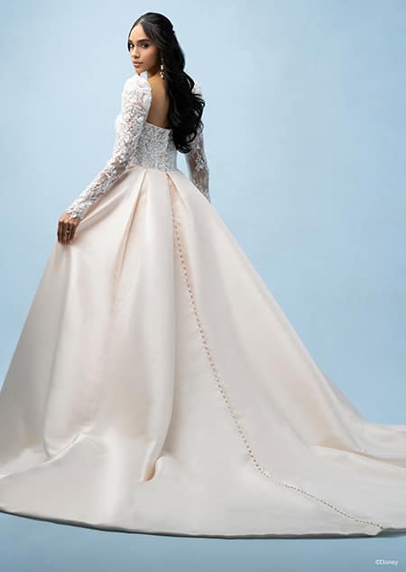 The back of a bride wearing a Belle inspired ball gown featuring a sleeved, beaded bodice and a train