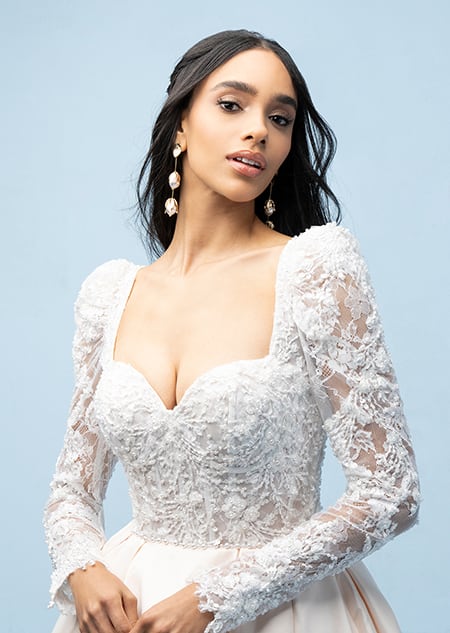 The bodice of a bride wearing a Belle inspired ball gown featuring sleeves, beading and a sweetheart neckline