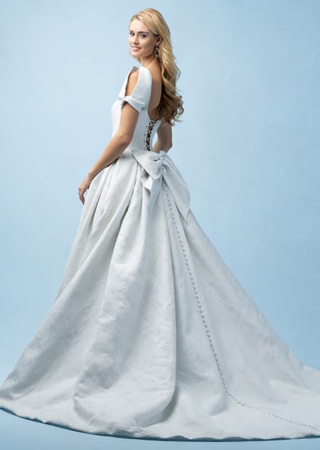 The side of a bride wearing a Cinderella inspired ball gown featuring cap sleeves and a train