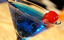 A martini glass filled with a cocktail topped with a cherry