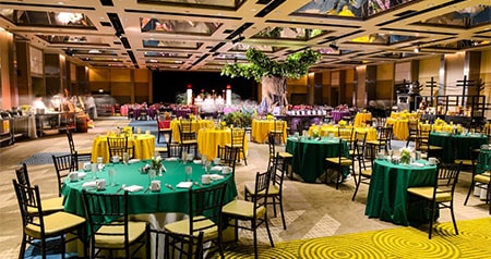 Set tables at a ballroom with an Alice in Wonderland theme