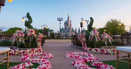 Cinderella's Castle near an outdoor wedding venue set with chairs and floral arrangements