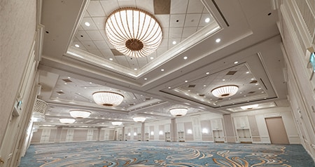 A large ballroom at Disney’s Grand Floridian Resort & Spa featuring ornate ceiling chandeliers and patterned carpet