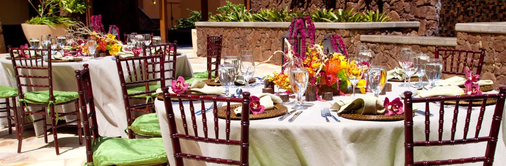 Two round tables surrounded by chairs on an outside patio