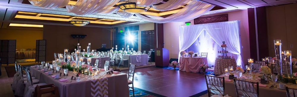 A softly glowing ballroom equipped with a dance floor and tables set for dinner