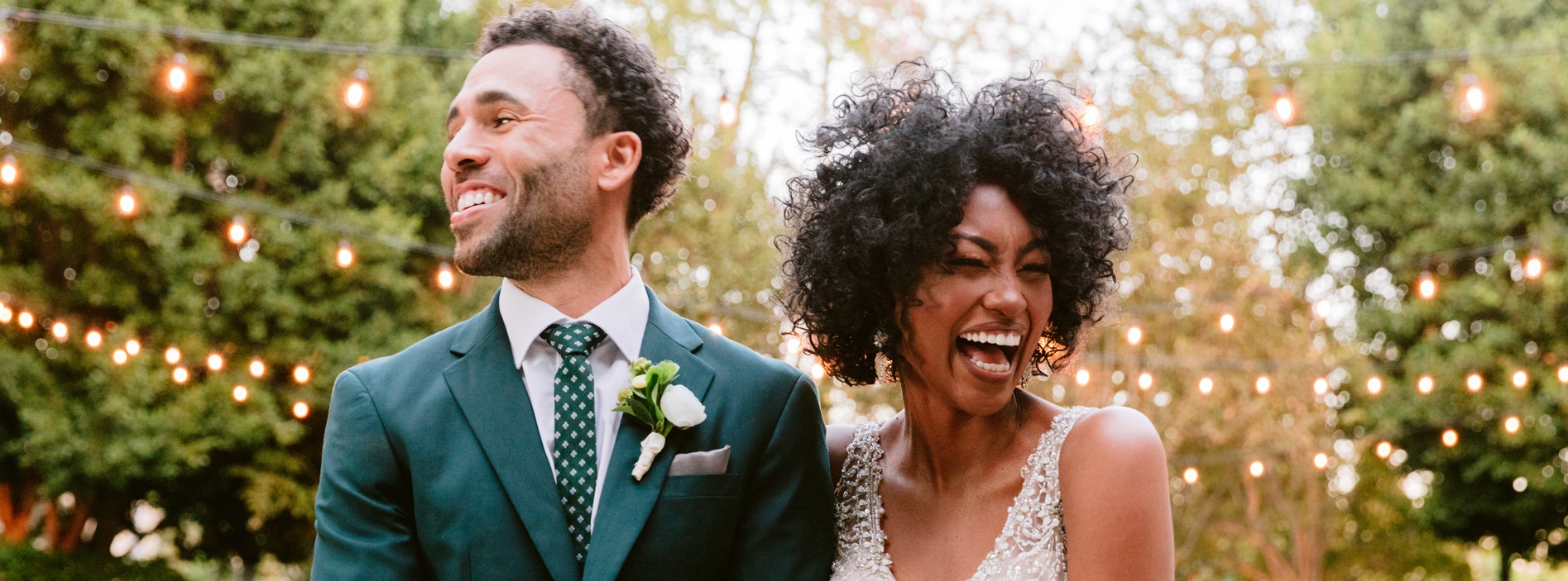 A couple in wedding attire embrace on an ornate bridge with Spaceship Earth in the background