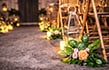 A wedding ceremony venue aisle lined with bamboo chairs, candles and floral arrangements with hidden Mickeys at Disney's Animal Kingdom theme park