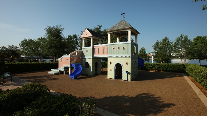 A playground with a cottage-shaped playhouse and slide