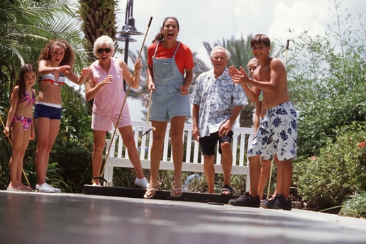 An extended family plays shuffleboard together