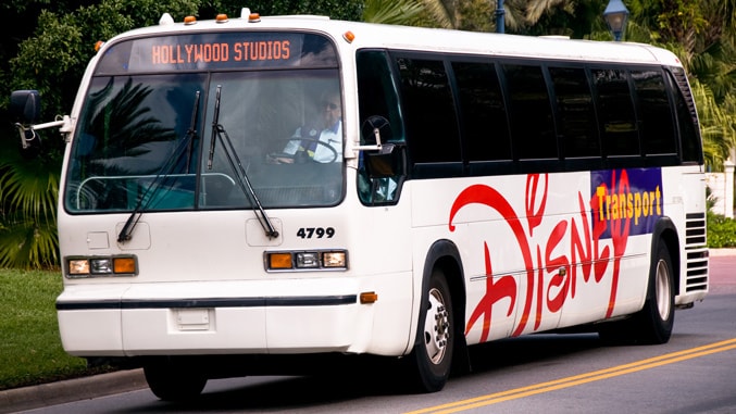 A Disney bus on a road, with a sign indicating that it's headed to Disney's Hollywood Studios park