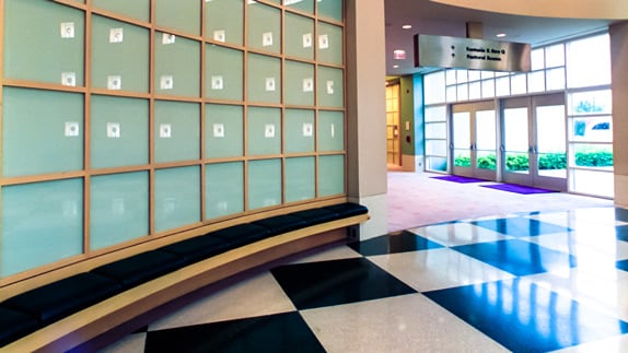 A large hall with a glass wall leading to a foyer with glass doors