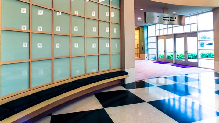 A large hall with a glass wall leading to a foyer with glass doors