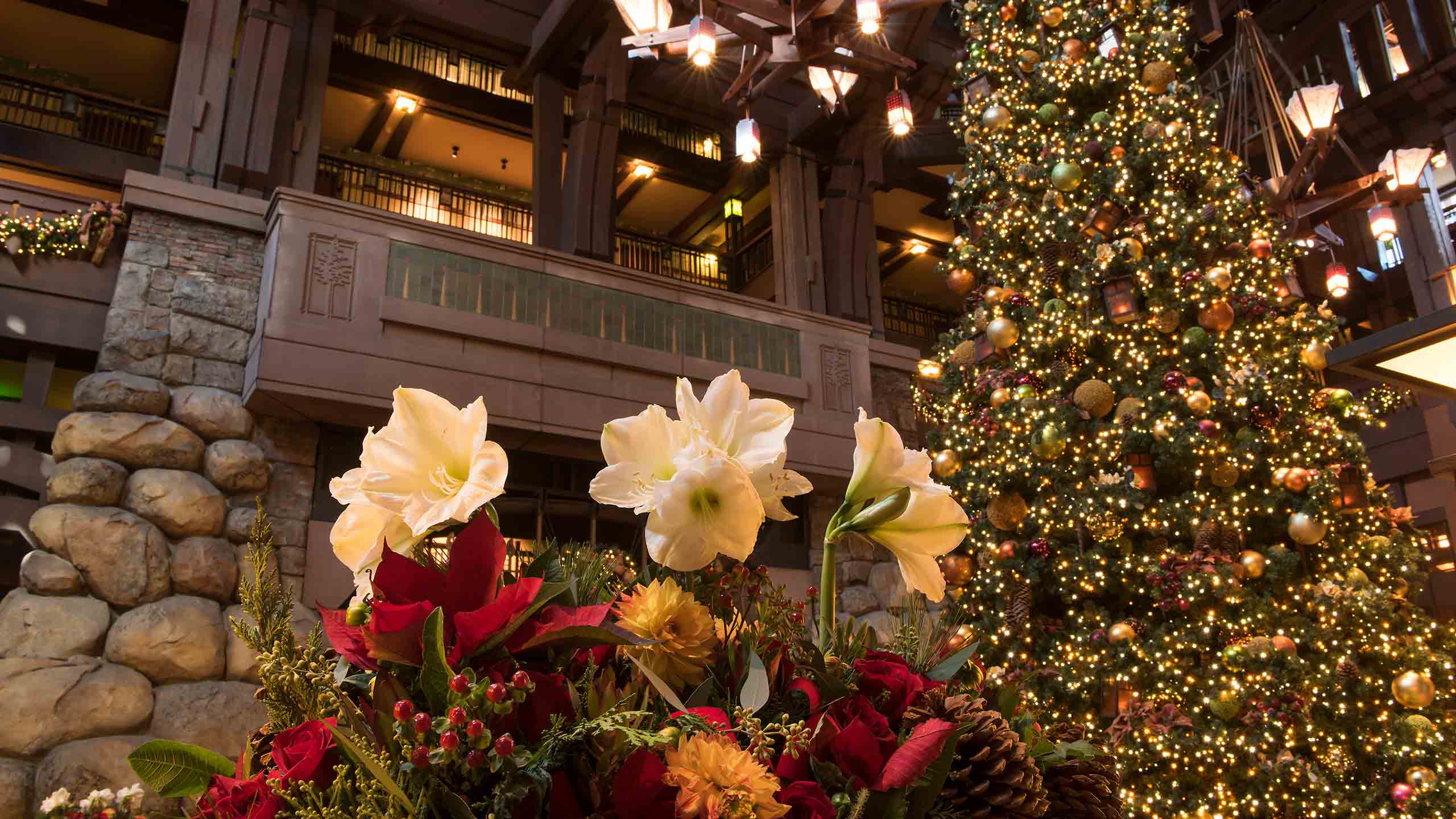 A holiday floral arrangement and a Christmas tree in the lobby of Disney's Grand Californian Hotel & Spa A holiday floral arrangement and a Christmas tree in the lobby of Disney's Grand Californian Hotel & Spa