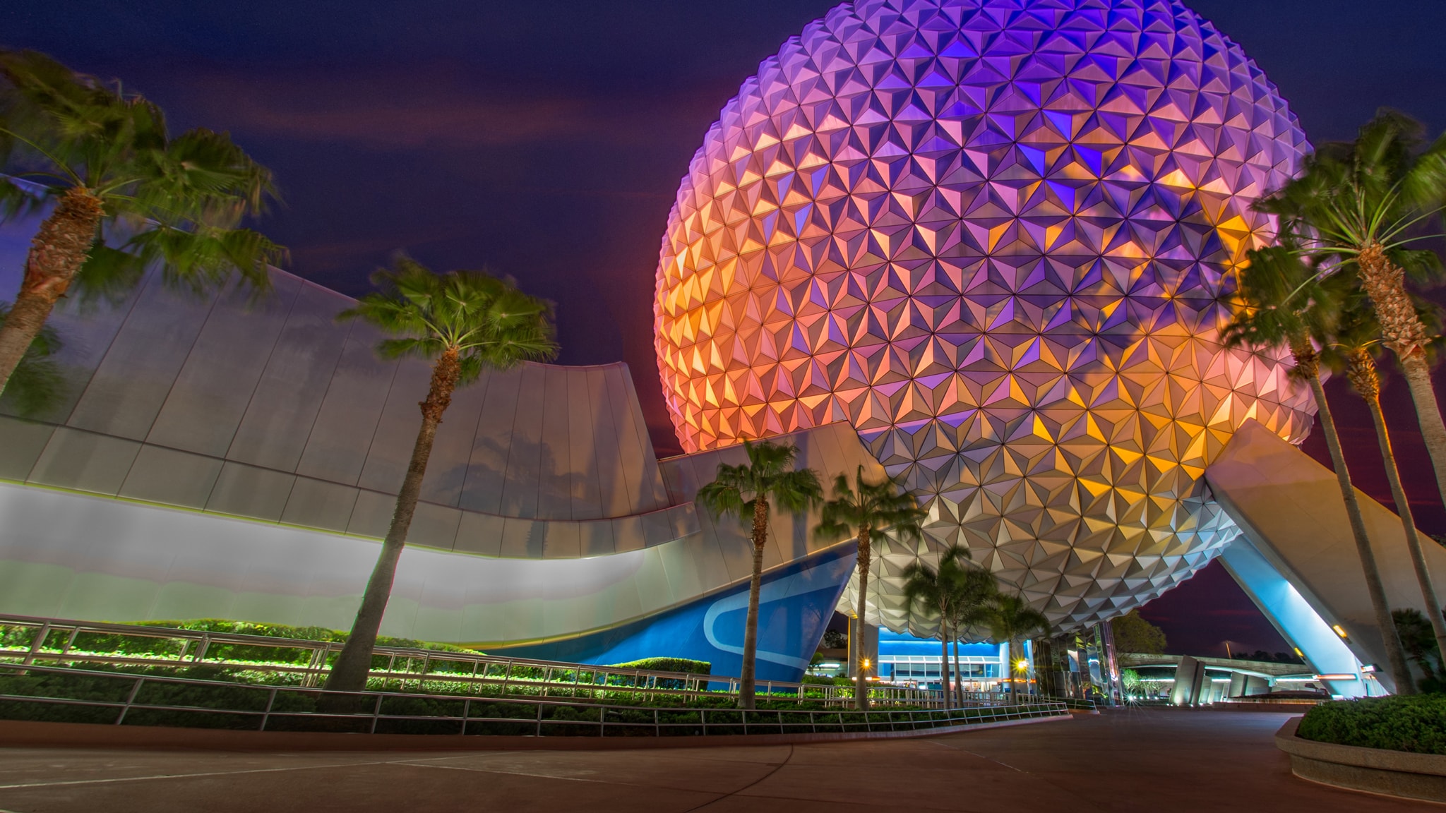 A brightly lit Christmas tree in front of Spaceship Earth at Epcot in Florida