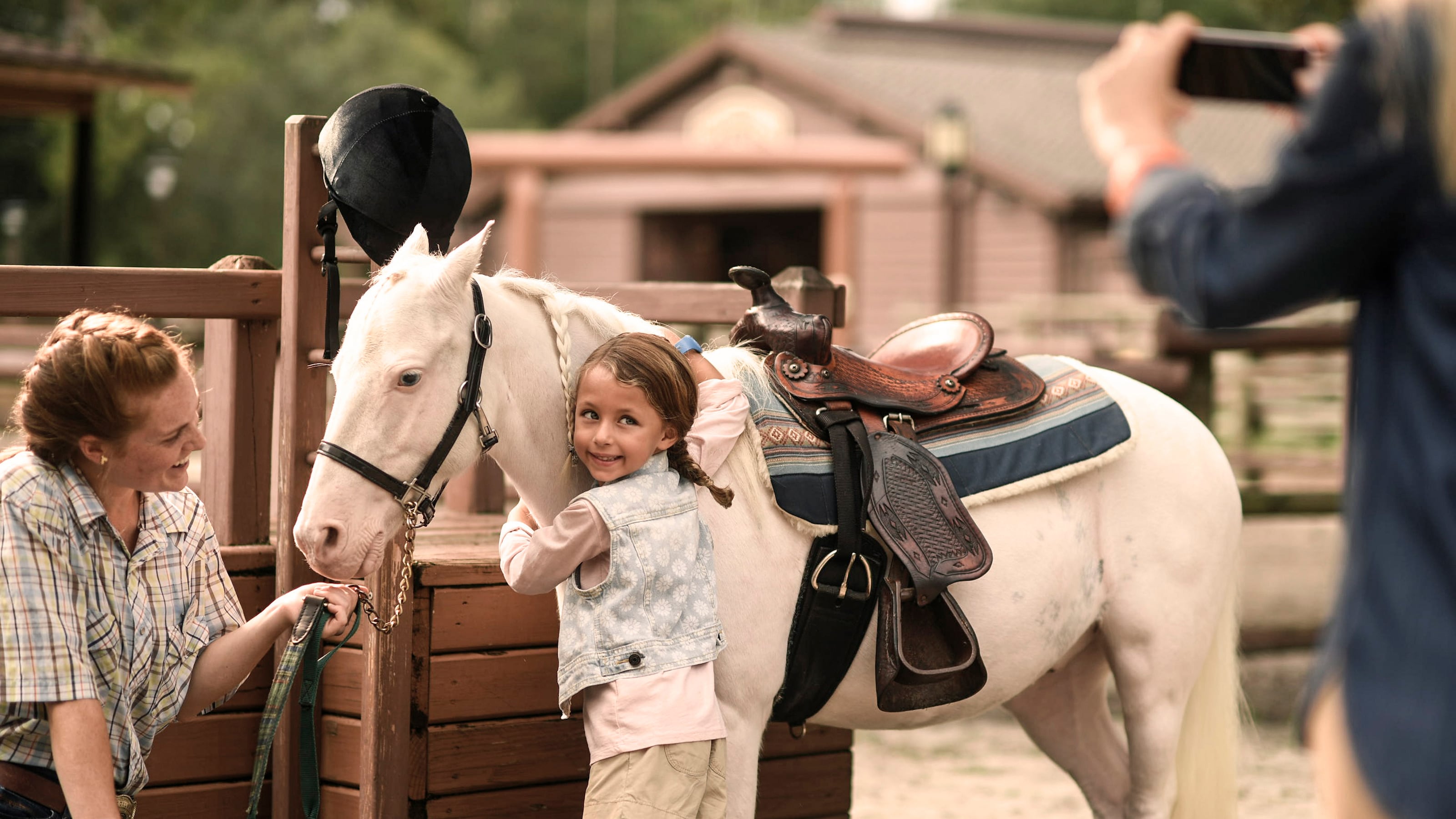 A girl poses for a photo while hugging a pony