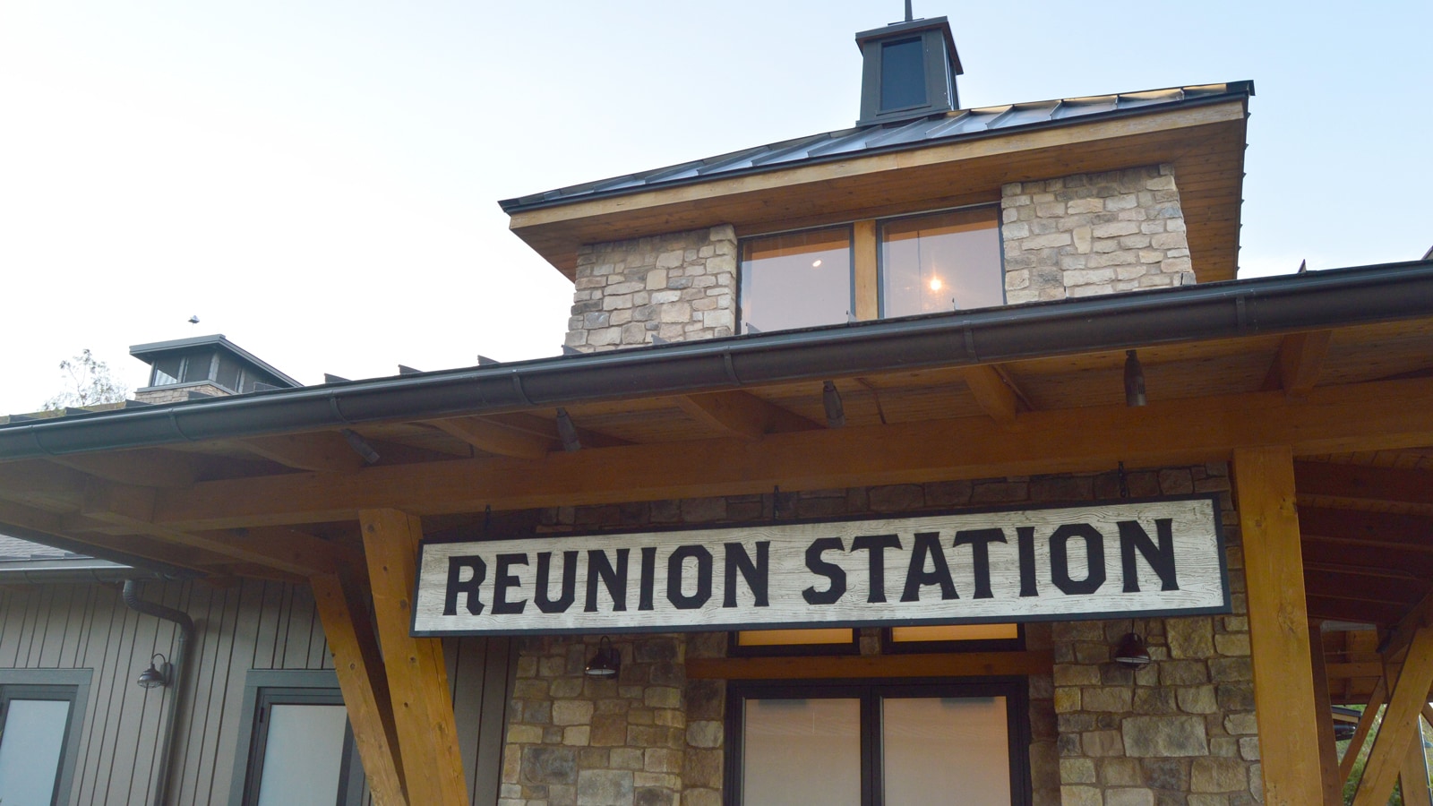 A wood and stone building with a sign that reads 'Reunion Station'