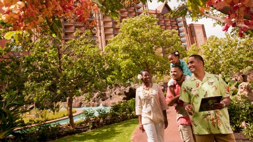 A Cast Member leading a family on a tour of the grounds at Aulani, A Disney Resort & Spa