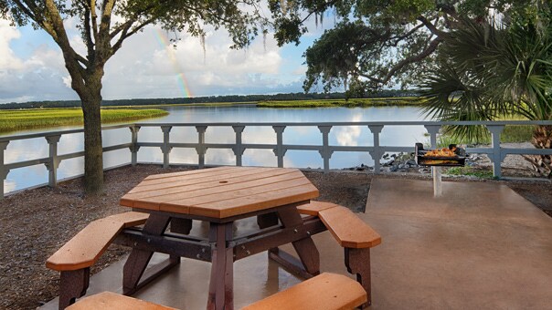 A picnic table and grill on a deck overlooking a waterway on Hilton Head Island