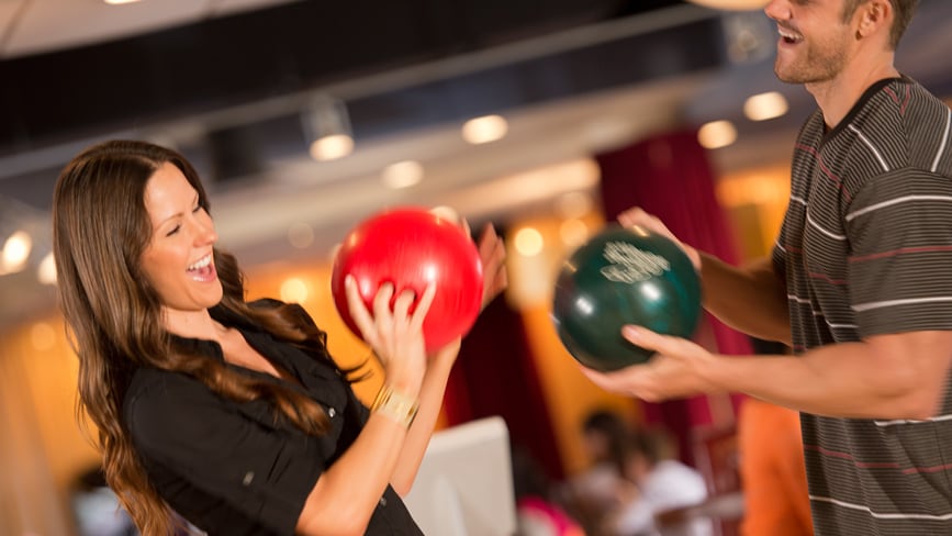A man and woman holding bowling balls