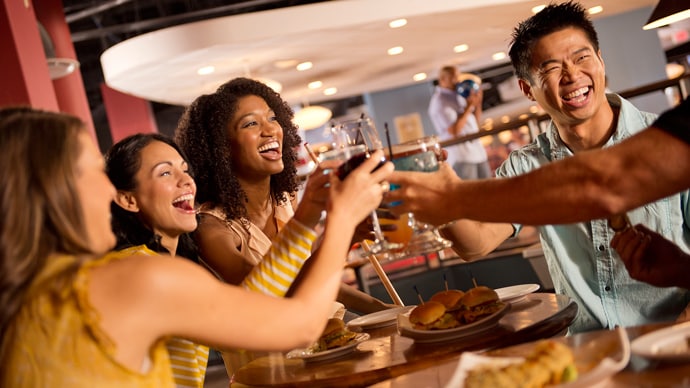 Young adults raising their glasses to toast in Splitsville Luxury Lanes at Disney Springs