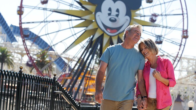 A couple walking in front of a ferris wheel at Disney California Adventure Park
