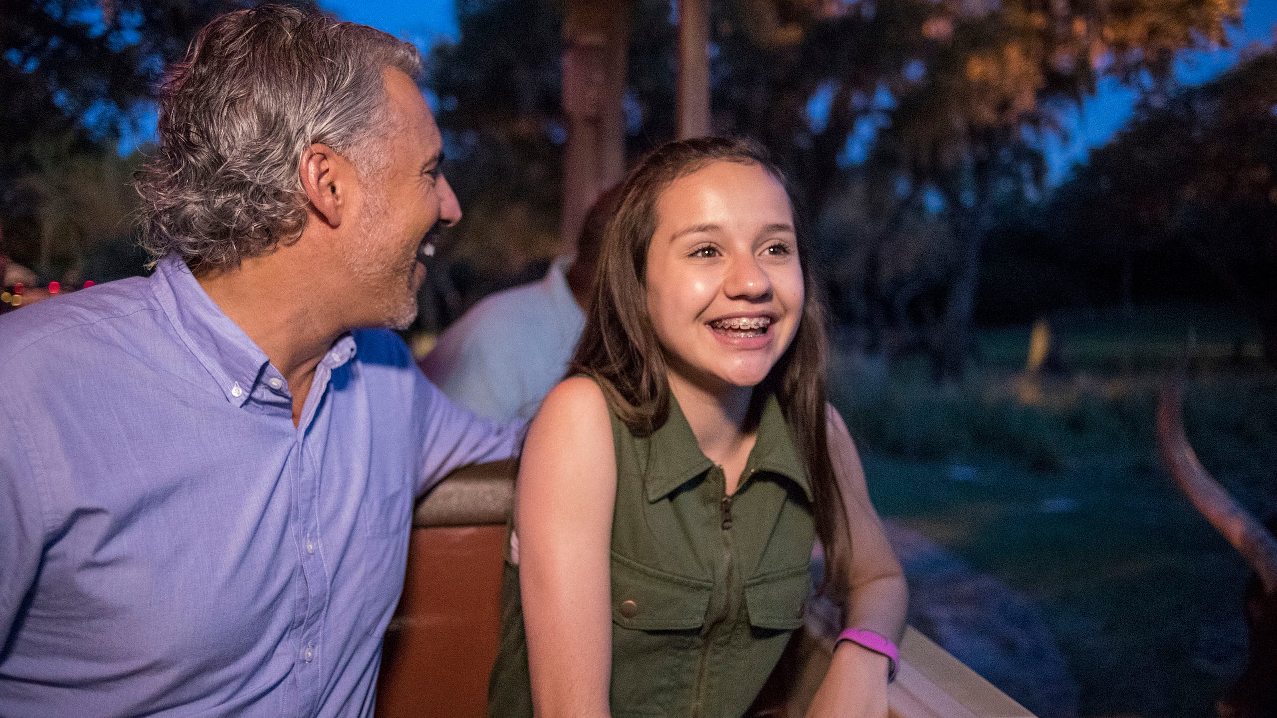 A man and a young girl seated in a safari vehicle