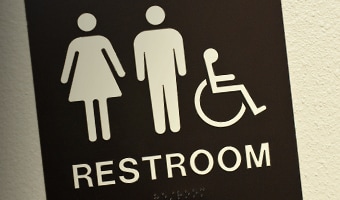 A restroom sign with icons of a woman, a man and a wheelchair