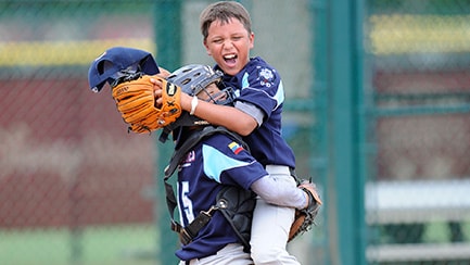 Un cátcher de béisbol abraza a su compañero