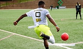 A player kicking a ball at home plate during a game of kickball