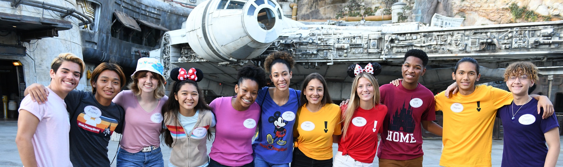 11 Disney Imagination Campus students stand in front of the Millennium Falcon in Star Wars Galaxy’s Edge